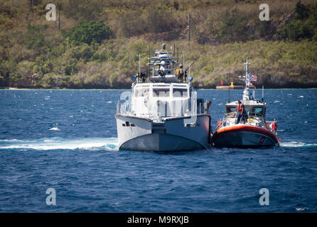 Velisti assegnati alle zone costiere squadrone fluviale (CRS) 4, det. Guam procedure di discutere con gli Stati Uniti Coast Guard velisti assegnati negli Stati Uniti. Coast Guard Settore Guam, durante un esercizio di traino in Apra Harbor, Guam, 28 marzo 2018. CRS-4, det. Guam è assegnato al comandante, Task Force 75, il primario expeditionary task force responsabile per la pianificazione ed esecuzione della costiera operazioni fluviali, l'eliminazione degli ordigni esplosivi, immersioni subacquee di ingegneria e costruzione, e la costruzione di sottomarini negli Stati Uniti 7 flotta area di operazioni. (U.S. Navy combattere la foto della telecamera tramite la comunicazione di massa Specialist 1a classe Stacy Foto Stock