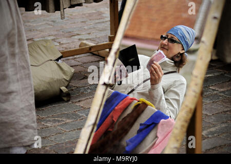 Riflesso in uno specchio di una donna di comprare qualcosa al mercato di Tallinn, Estonia Foto Stock