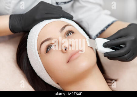 Trattamento viso di pulizia ad ultrasuoni con speciale dispositivo in un salone di bellezza. Foto Stock