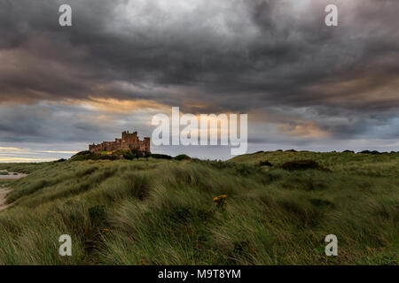 Il castello di Bamburgh alba sul litorale di Northumberland Foto Stock