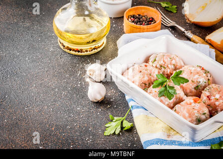 Materie in casa di pollo o la Turchia le polpette di carne in una teglia scuro dello sfondo arrugginito. Spazio di copia Foto Stock