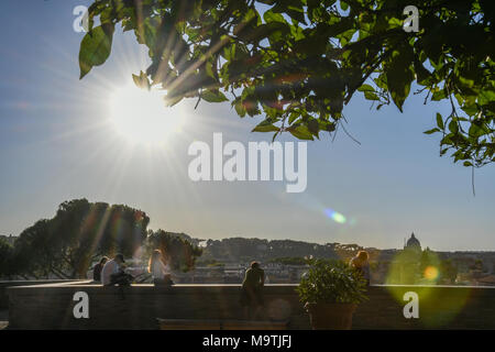 La gente seduta sulla sommità del colle Aventino in attesa per la spettacolare esibizione del tramonto sul capitale italiana della città di Roma Foto Stock