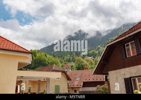 Strada di un piccolo paese di montagna di Slovenia, l'Europa. Squallido case vecchie facciate e tetti Foto Stock