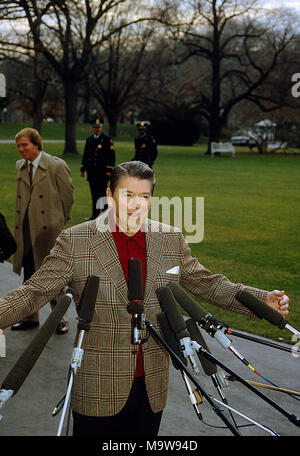 Washington, DC, Stati Uniti d'America, Dicembre 27, 1984 Presidente Ronald Reagan parla con i giornalisti al di fuori del Sud Portico ingresso come lui e la First Lady Nancy Reagan prepararsi a bordo uno marino per il volo per Andrews AFB per viaggio in California. Credito: Mark Reinstein/MediaPunch Foto Stock