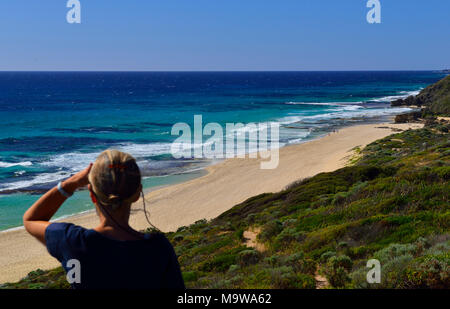 Donna che guarda verso nord lungo Yallingup Beach in direzione di Cape Naturaliste Lighthouse ,Yallingup, Australia occidentale Foto Stock