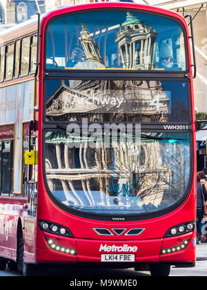 La Cattedrale di St Paul e riflessa nei vetri anteriori di un rosso London bus Foto Stock