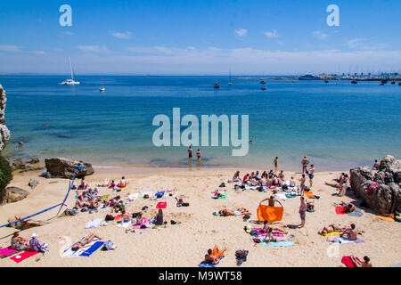 La gente a prendere il sole sulla spiaggia a Cascais, Portogallo Foto Stock