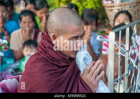 Monaco buddista di pregare presso la Golden Rock in Kyaiktiyo Foto Stock