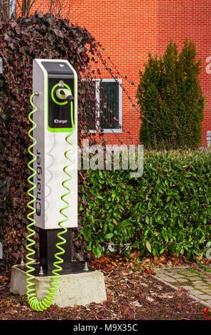 Electric Car Charger all'esterno, accanto a un edificio per uffici. Foto Stock