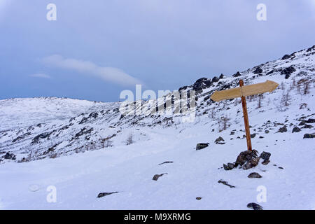 A due vie senza orientamento iscrizioni in un deserto inverno paesaggio di montagna Foto Stock