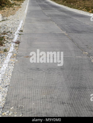 Strada da lastre in calcestruzzo. In calcestruzzo armato sulla strada. La superficie stradale per il trasporto industriale. Foto Stock