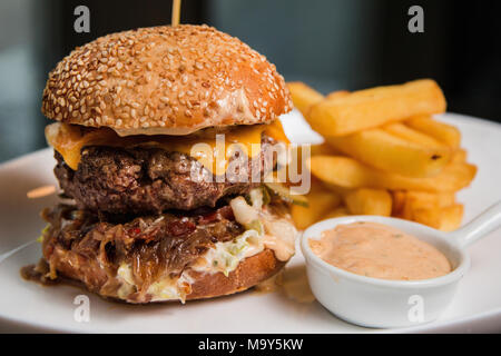 In prossimità di una gustosa burger con salsa di pomodoro e patate fritte Foto Stock