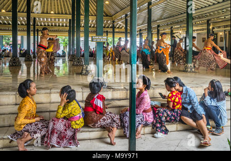 Corte femmina ballerini guardando su, come maschio ballerini eseguono Beksan Putra e tradizionale palazzo maschio performance di danza presso il Kraton Ngayogyakarta Hadining Foto Stock