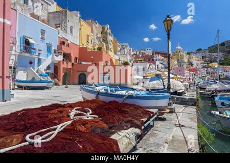 Grazioso villaggio di pescatori, colorate case di pescatori e reti da pesca, Marina Corricella Isola di Procida e della baia di Napoli, Italia. Foto Stock