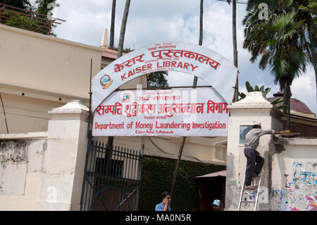 Il Nepal 2014. Kathmandu . Ingresso al dipartimento di inchiesta in materia di riciclaggio con un uomo su una scala la riparazione di una luce Foto Stock