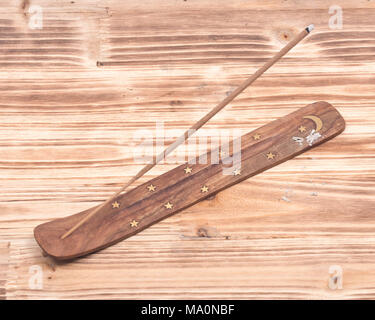 Intagliato a mano bruciatore, titolare con il legno di sandalo incenso su legno sfondo vintage Foto Stock