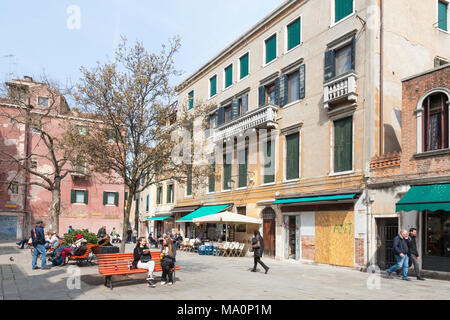 Campo Santa Maria Nova, Cannaregio, Venezia, Veneto, Italia con locale veneziani e turisti che si siedono sui banchi godendo il sole invernale Foto Stock