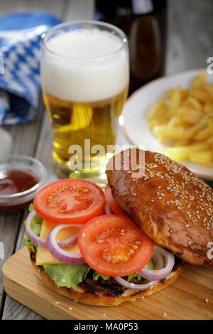 Deliziosi hamburger con verdure e una cotoletta. Panino con birra e patatine fritte di close-up Foto Stock