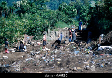 Tz indigeni'utujil Maya di ragazzi che giocano a calcio (calcio) in corrispondenza di una discarica di rifiuti (heap) in San Lucas Tolimán, Guatemala. Foto Stock