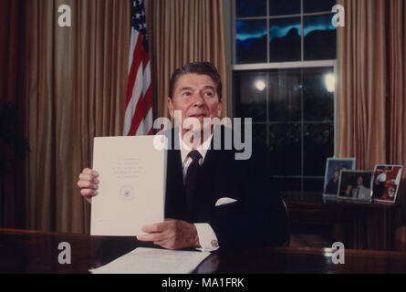 Washington DC., Stati Uniti d'America, 28 maggio 1985 il Presidente Ronald Reagan trattiene una copia della proposta di riforma fiscale bill durante il suo TV discorso alla nazione dall'Ufficio Ovale. Credito: Mark Reinstein/MediaPunch Foto Stock