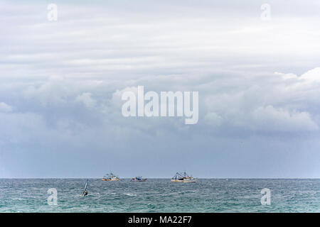 Campeche, Florianópolis, Brasile. Februry, 2018. Barche e surfisti in acqua sotto un cielo enorme, Foto Stock