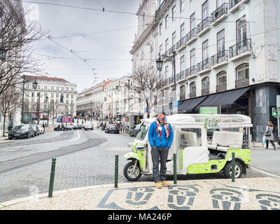 7 Marzo 2018: Lisbona, Portogallo - Tuk Tuk driver wrappede fino a caldo, in attesa di business per le strade di Lisbona in primavera. Foto Stock