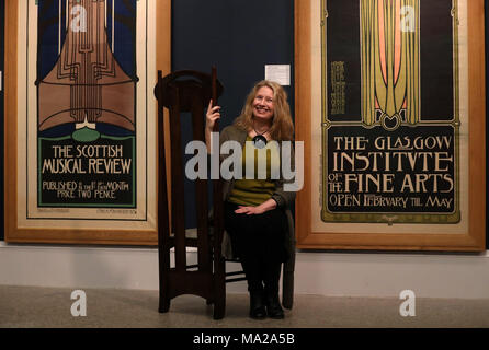 Il curatore Alison Brown si trova di fronte ai poster l-r Scottish Musical Review 1896, litografia, di Charles Rennie Mackintosh e Glasgow Institute of fine Arts, litografia, di James Herbert McNair, Frances Macdonald e Margaret Macdonald al lancio di Charles Rennie Mackintosh che ha allestito la mostra in stile Glasgow presso il Kelvingrove Art Gallery and Museum di Glasgow. La mostra celebra il 150° anniversario della nascita della più grande icona culturale della città, Charles Rennie Mackintosh. Foto Stock