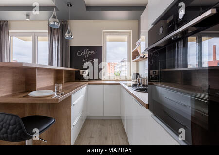 Cucina in stile contemporaneo con pavimenti in legno e bianco mobili da cucina Foto Stock