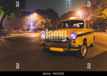 Yellow classic al servizio taxi aeroporto di Kolkata parcheggio a notte. Un taxi modello 50s-60s. Foto Stock