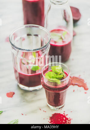 Fresca del mattino frullato di barbabietola con la menta in vetro e una bottiglia Foto Stock