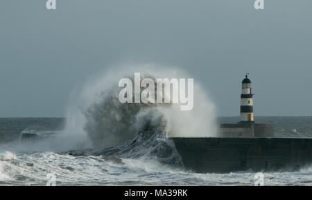 Enormi onde dal Mare del Nord colpiscono e si schiantano sul molo e sul faro di Seaham nella Contea di Durham Foto Stock