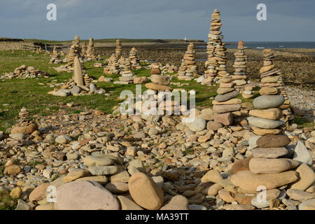 pietra memoriale cairns che conduce all'immagine e costruito dai visitatori su Lindisfarne anche conosciuta come Isola Santa in Northumberland Foto Stock