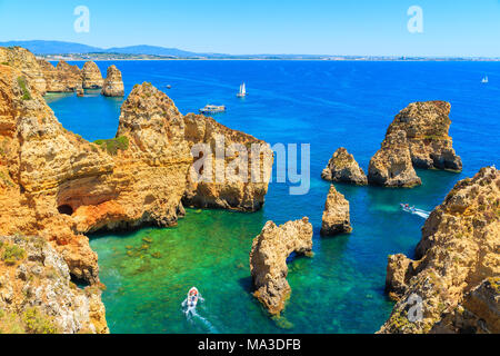 Cliff rocce e la barca turistica sul mare a Ponta da Piedade, regione di Algarve, PORTOGALLO Foto Stock