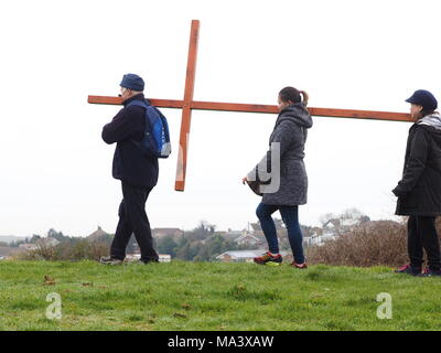 Cattedrale sul mare, Kent, Regno Unito. Il 30 marzo, 2018. Buon Venerdì cerimonia: Chiese insieme in Sheppey (I CTI) annuo Processione del Venerdì Santo di testimonianza. Tre croci di legno sono stati portati da Sheerness, Eastchurch e a metà strada per una cerimonia di premiazione che si terrà sotto la pioggia in cima al Glen in Cattedrale sul mare, uno dei punti più alti del Isle of Sheppey. Il semplice servizio è organizzato per tutte le denominazioni da Chiese insieme in Sheppey (I CTI) ed è stata tenuta sull'isola verde della collina per più di 35 anni. Credito: James Bell/Alamy Live News Foto Stock