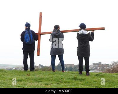 Cattedrale sul mare, Kent, Regno Unito. Il 30 marzo, 2018. Buon Venerdì cerimonia: Chiese insieme in Sheppey (I CTI) annuo Processione del Venerdì Santo di testimonianza. Tre croci di legno sono stati portati da Sheerness, Eastchurch e a metà strada per una cerimonia di premiazione che si terrà sotto la pioggia in cima al Glen in Cattedrale sul mare, uno dei punti più alti del Isle of Sheppey. Il semplice servizio è organizzato per tutte le denominazioni da Chiese insieme in Sheppey (I CTI) ed è stata tenuta sull'isola verde della collina per più di 35 anni. Credito: James Bell/Alamy Live News Foto Stock