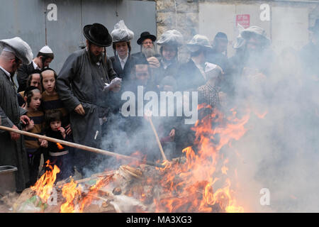 Gli ebrei Haredi bruciano pane e altri prodotti contenenti lievito durante il rituale di Biur Chametz, mentre si preparano per la festa ebraica di Pesach (Pasqua) nel quartiere di Mea Shearim, un'enclave ultra-ortodossa a Gerusalemme Ovest Israele. Una legge centrale dell'osservanza della Pasqua è quella di rimuovere ogni traccia di hametz, che significa 'leaven' in ebraico che è proibito nella festa ebraica della Pasqua. Foto Stock