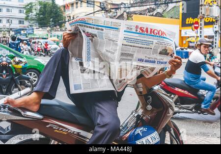 Uno scooter taxi driver in attesa per i clienti nella città di Ho Chi Minh, Vietnam Foto Stock