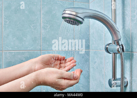 Due palma umana in manciate sotto flusso di acqua dal box doccia. Foto Stock