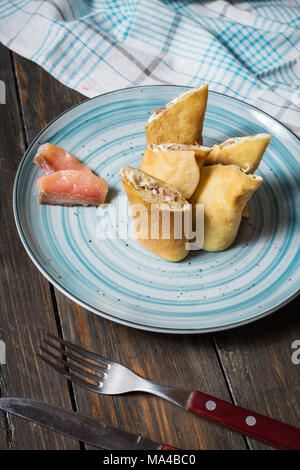 Frittelle con salmone e crema di formaggio su uno sfondo di legno Foto Stock