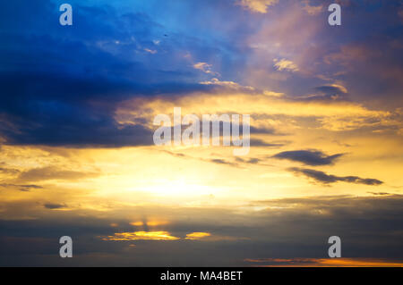 Nuvole al tramonto. I raggi luminosi del sole fra le nuvole di tempesta al tramonto di una sera d'estate Foto Stock