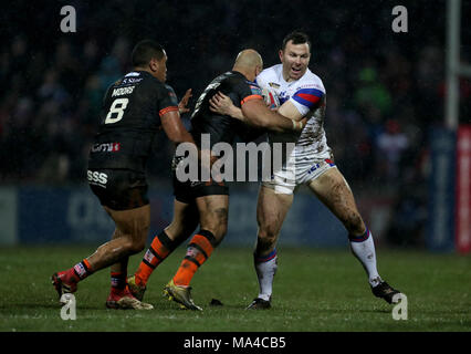 Wakefield Trinità di Keegan Hirst è affrontato da Castleford Tigers Jake Webster e Castleford Tigers Junior mori durante la Super League match al Belle Vue, Wakefield. Foto Stock