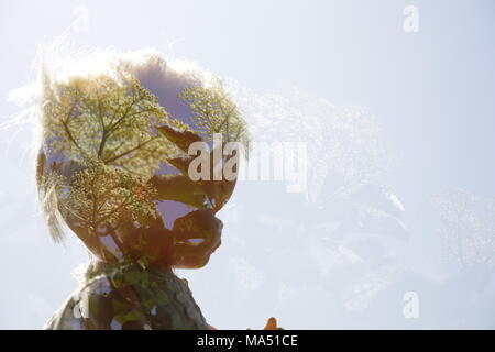 Testa di bambole con fiori e piante in doppia esposizione Foto Stock