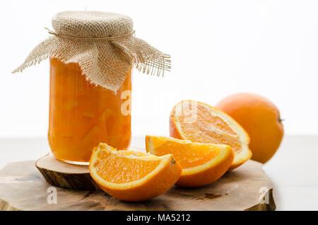 Orange marmellata fatta in casa e fette di arance sul tavolo di legno Foto Stock