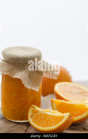 Orange marmellata fatta in casa e fette di arance sul tavolo di legno Foto Stock