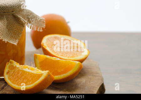Orange marmellata fatta in casa e fette di arance sul tavolo di legno Foto Stock