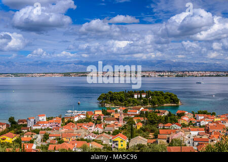 Croazia, Dalmazia, arcipelago di Zadar, isola di Ugljan, Preko, vista città con monastero isola Galovac verso Zara con le montagne di Velebit Foto Stock