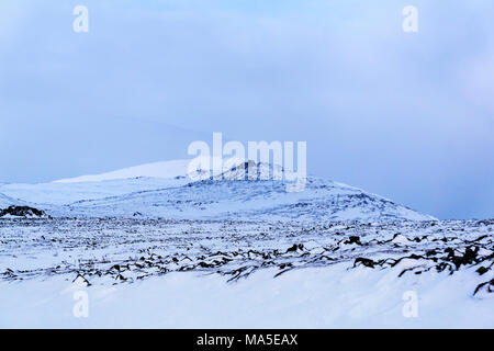 Snowy altopiano con un blu ombra da una nuvola su un picco di montagna in background Foto Stock