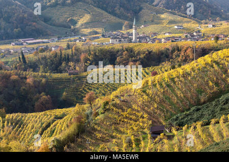 Il villaggio di Guia circondato dai vigneti di giallo in autunno, come si vede dalla strada del vino, Valdobbiadene, Treviso, Veneto, Italia Foto Stock