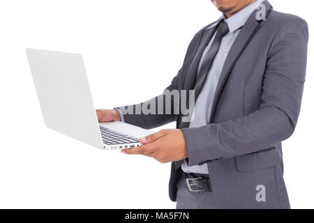 Business man in tuta con computer portatile isolato su sfondo bianco Foto Stock