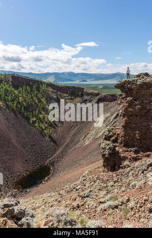 L'uomo ammirate Khorgo cratere del vulcano. Distretto Tariat, Nord provincia Hangay, Mongolia. Foto Stock